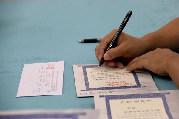 徐龍海在《入學(xué)通知書(shū)》上寫(xiě)下學(xué)生名字。金山小學(xué)供圖