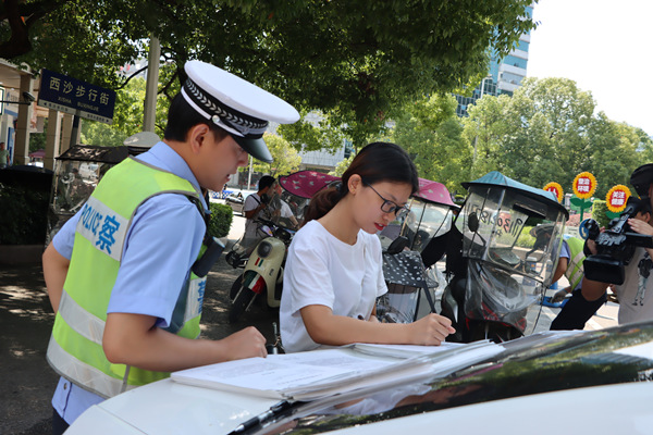 引導(dǎo)摩托車駕乘人員簽訂承諾書。黔江區(qū)委宣傳部供圖