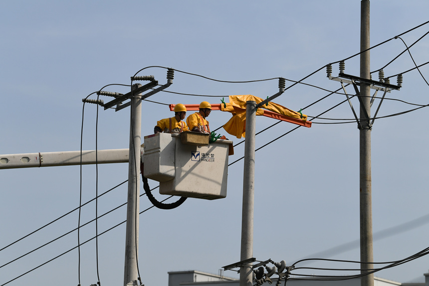 電力公司工作人員在巴南區(qū)界石鎮(zhèn)虎嘯村開展帶電作業(yè)。潘洪攝