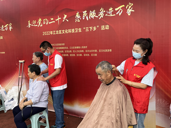 青年志愿者為老人公益剪發(fā)、按摩。蔣海濤攝