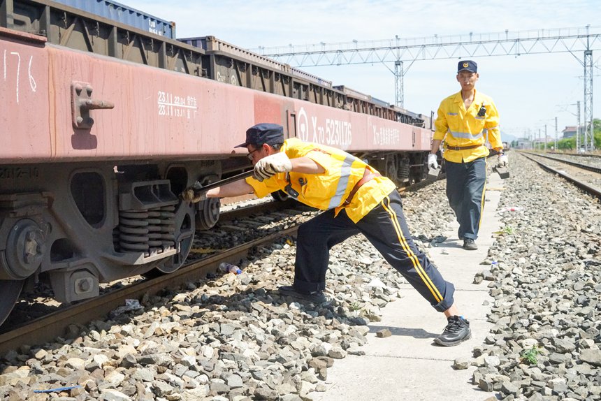 8月9日，重慶西車輛段貨車檢車員正在處置中歐班列閘瓦故障。劉彪攝