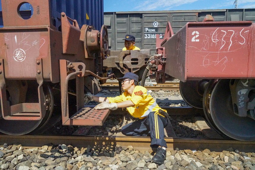 8月9日，重慶西車(chē)輛段貨車(chē)檢車(chē)員正在進(jìn)行檢查中歐班列鉤緩連接部技術(shù)狀態(tài)。劉彪攝