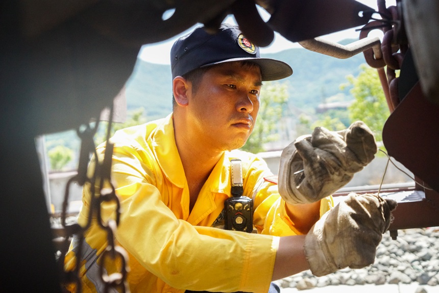 8月9日，重慶西車輛段貨車檢車員正在捆綁中歐班列人力制動(dòng)機(jī)鏈。劉彪攝