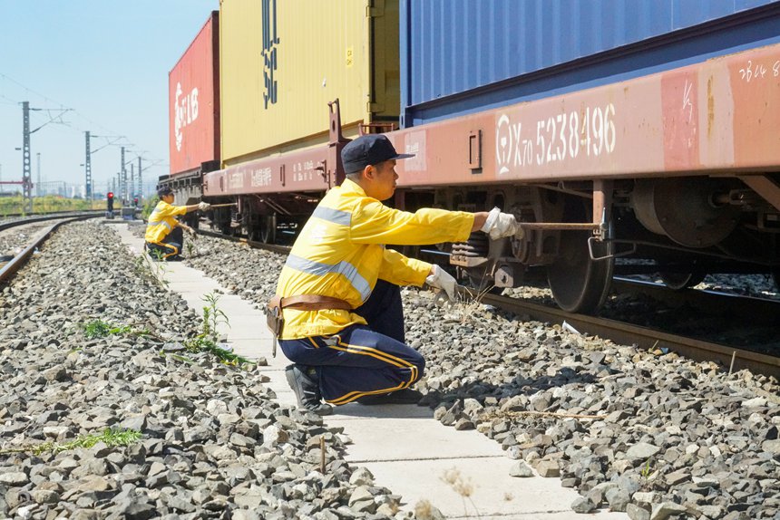8月9日，重慶西車輛段貨車檢車員正在確認(rèn)中歐班列制動缸狀態(tài)。劉彪攝