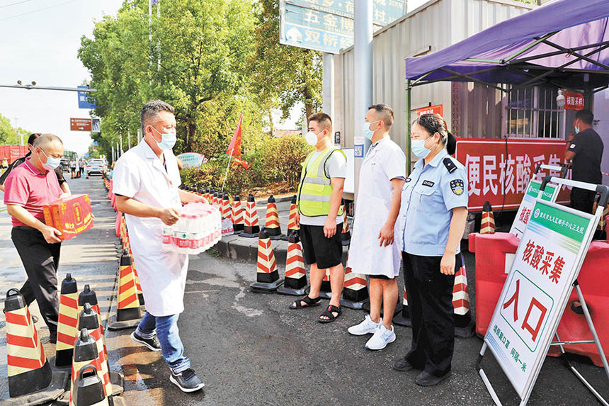 8月16日，成渝高速公路大足郵亭站核酸檢測點，郵亭鎮(zhèn)工作人員送來防暑降溫藥品、飲料等，保護核酸檢測點工作人員身心健康。通訊員 譚顯全 攝/視覺重慶
