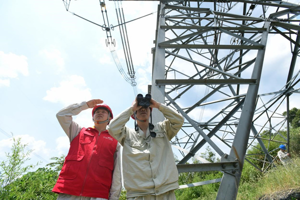 國(guó)網(wǎng)江津區(qū)供電公司員工對(duì)重要輸電線路鐵塔周邊的防火情況進(jìn)行巡查。