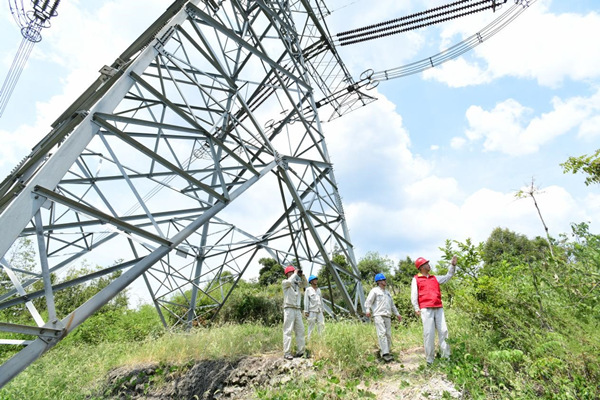 國網(wǎng)江津區(qū)供電公司員工對重要輸電線路鐵塔周邊的防火情況進(jìn)行巡查。王化全攝