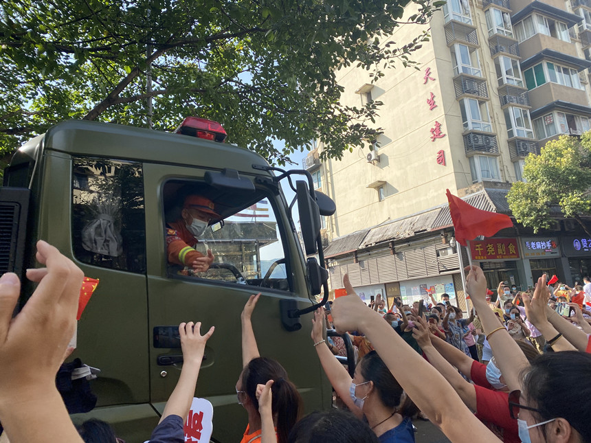 重慶市民豎著大拇指歡送滅火英雄。楊歡攝