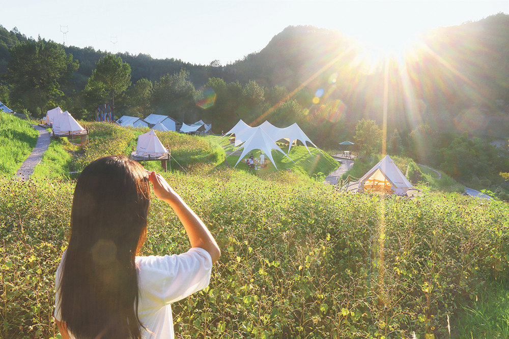 7月29日,石柱橋頭鎮(zhèn)喜馬拉雅野奢露營地,游客以白色帳篷為背景拍照留念。特約攝影 鐘志兵/視覺重慶