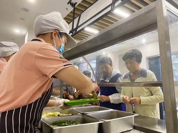 老年居民在社區(qū)食堂吃飯。唐鑫 攝