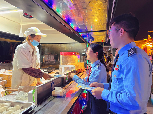 榮昌區(qū)稅務(wù)人員走進(jìn)榮昌區(qū)夏布小鎮(zhèn)的夜市宣傳稅收優(yōu)惠政策。黃佳攝