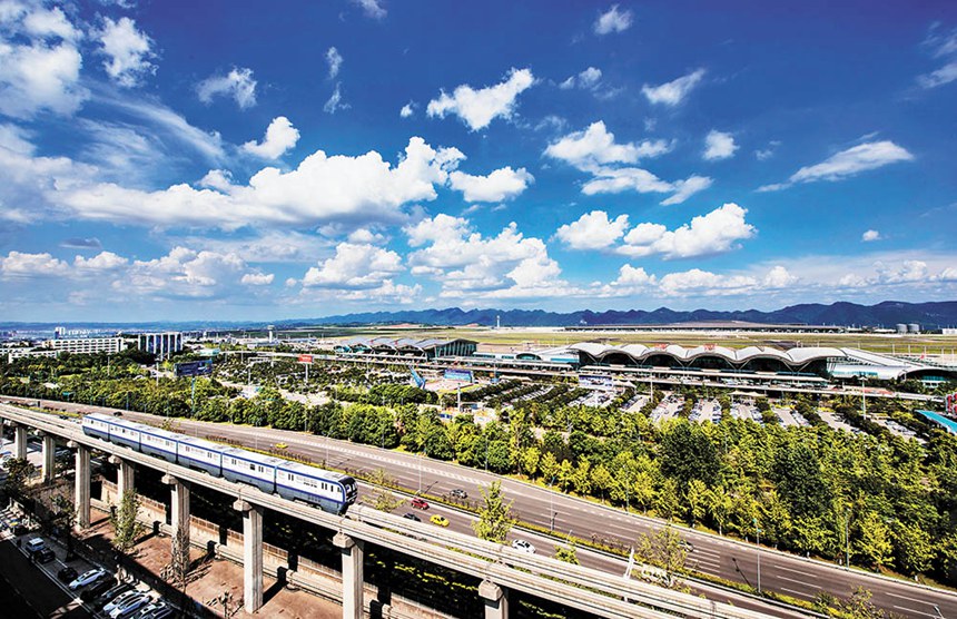 一輛軌道列車從江北國際機(jī)場旁駛過。江北國際機(jī)場是中西部首個三條跑道、三座航站樓同時運行的機(jī)場，邁入全球繁忙機(jī)場行列。許可 攝