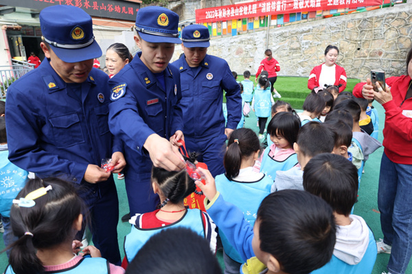 消防員給小朋友發(fā)放禮品。彭水縣消防救援大隊供圖