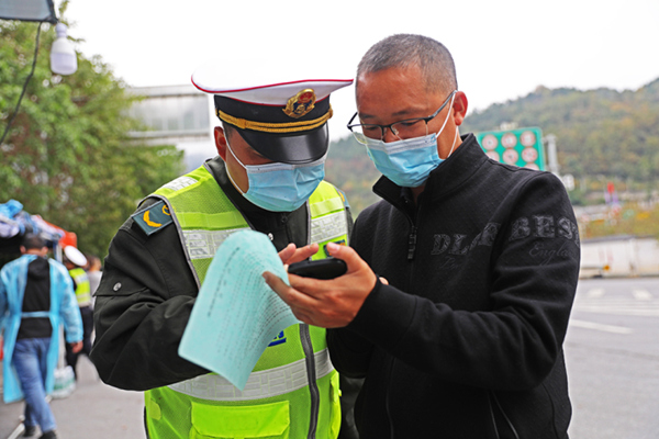 交通卡口防疫人員在查看入彭群眾健康碼。趙勇攝