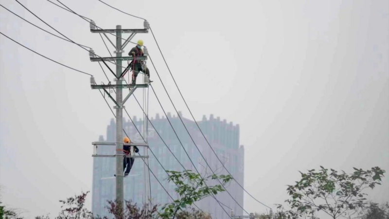 施工現(xiàn)場電力工人正在架設(shè)線路。向江微攝