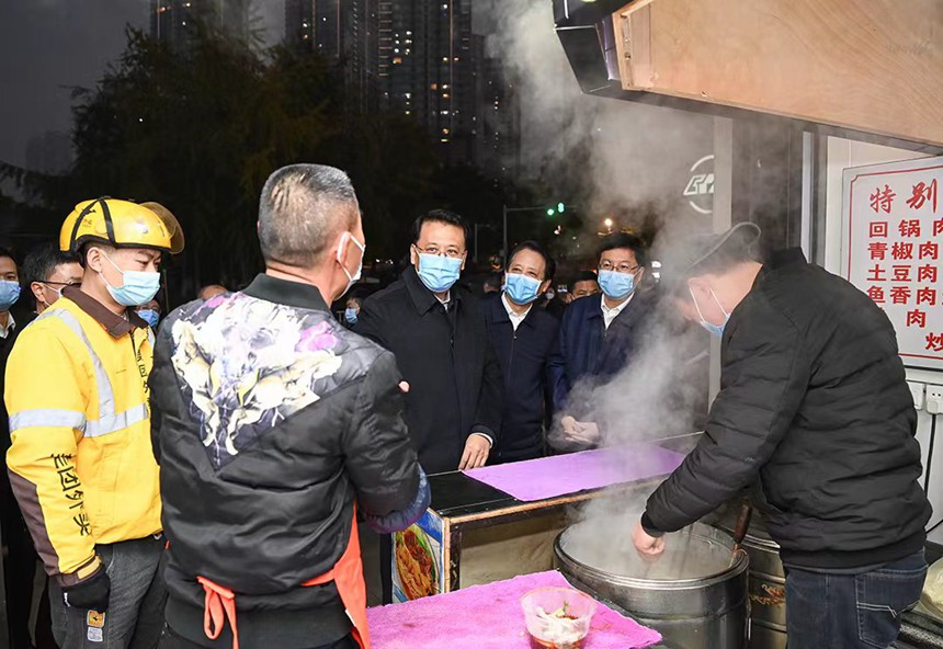 12月12日下午，在解放碑中央商務區(qū)，市委書記袁家軍同面館老板交流。記者 蘇思 攝/視覺重慶