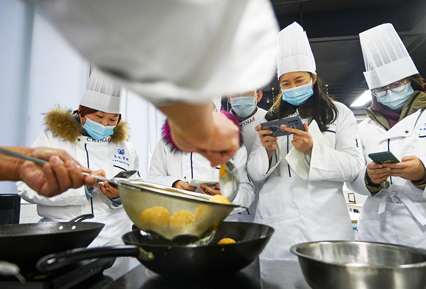 為幫助就業(yè)困難人員掌握一技之長，渝北區(qū)人力社保局開辦各類免費(fèi)技能培訓(xùn)班。圖為學(xué)員們正在老師指導(dǎo)下學(xué)習(xí)制作重慶小吃。(資料圖片）記者 萬難 攝/視覺重慶