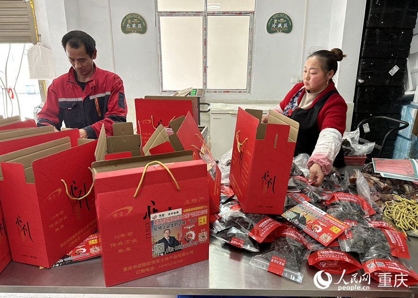 胡文超（左）在打包農(nóng)副產(chǎn)品。人民網(wǎng) 劉政寧攝