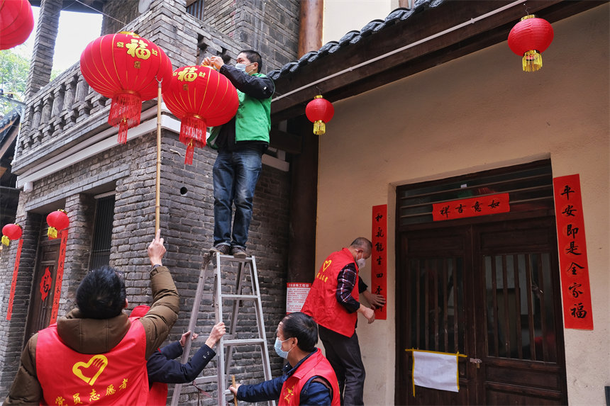 志愿者們正在為黃葛古道敦厚坡段的傳統(tǒng)民居懸掛燈籠。郭旭攝