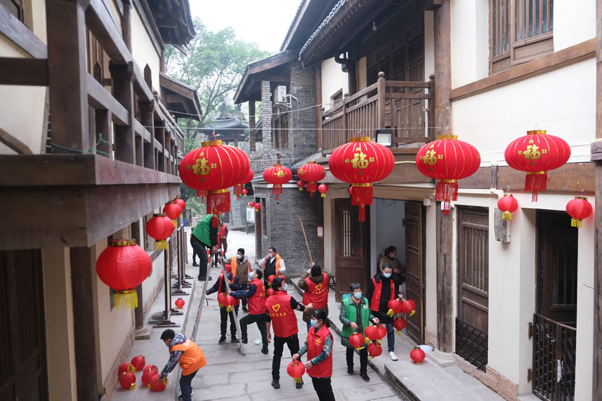志愿者們正在為黃葛古道敦厚坡段的傳統(tǒng)民居貼春聯(lián)，掛燈籠。郭旭攝