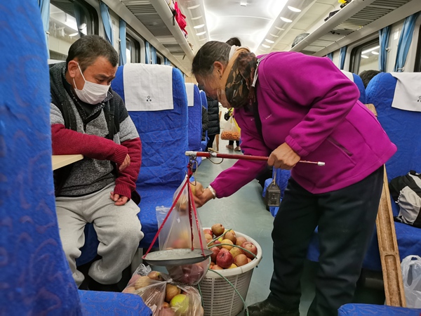 乘客在列車上購買蘋果。張章攝