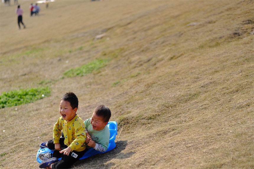 孩子們沐浴著陽(yáng)光，在草坪上盡情撒歡。郭旭攝