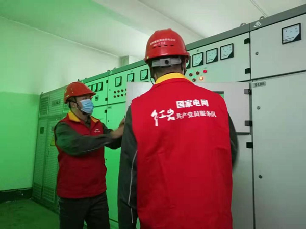 國網(wǎng)彭水供電公司紅巖共產(chǎn)黨員服務隊隊員正在檢查配電柜。蔡光進攝