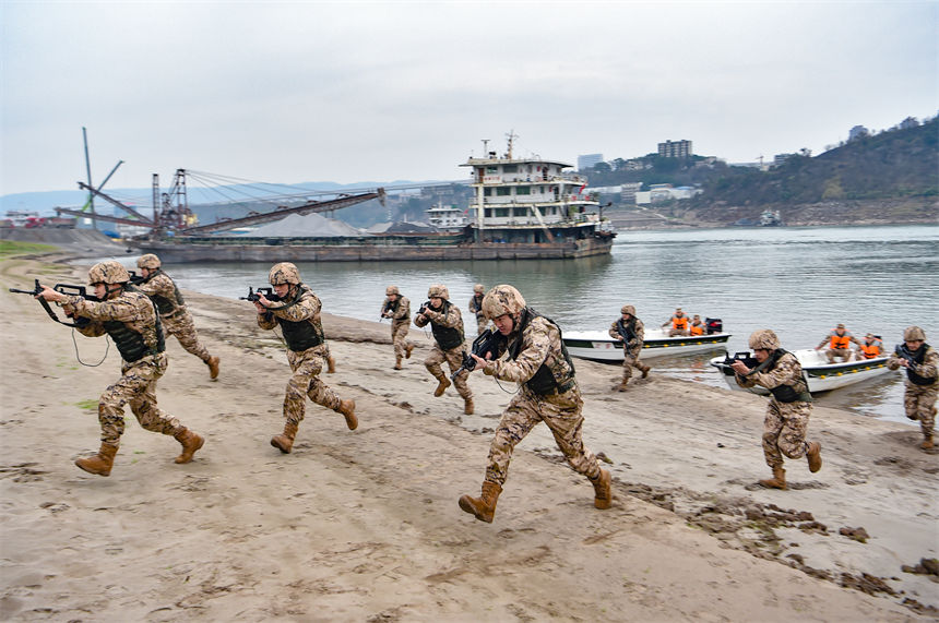武警重慶總隊船艇支隊組織水上實戰(zhàn)化演練，特戰(zhàn)隊員搶灘登陸對“暴恐分子”進行追捕。唐志勇攝