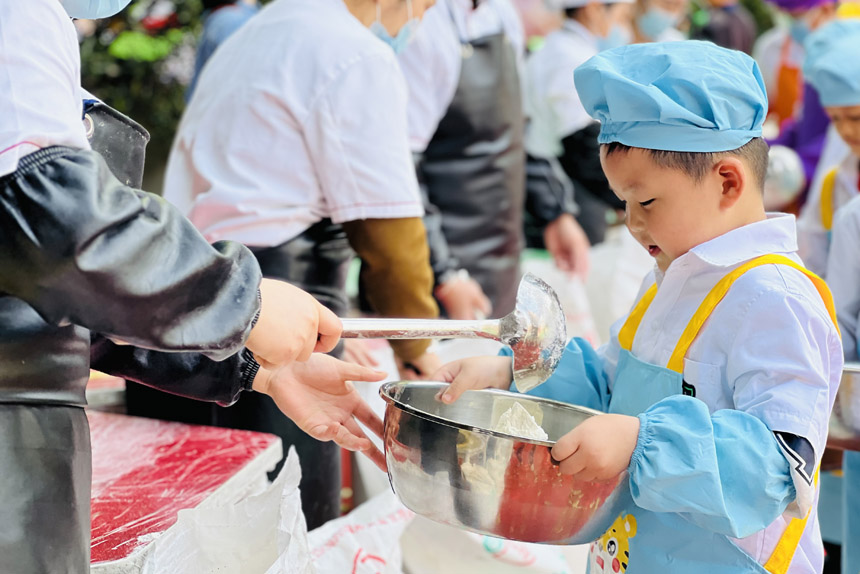 幼兒園小朋友排隊(duì)領(lǐng)面粉。晏玉雪攝