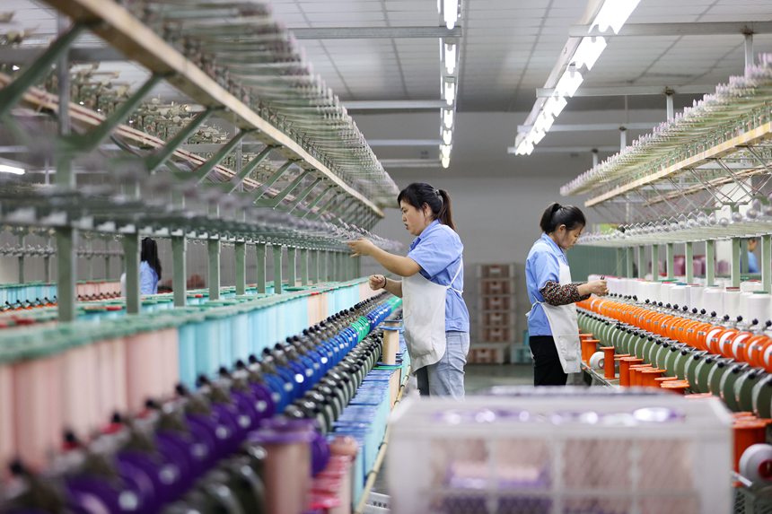 絲綢紡織女工在生產(chǎn)車間忙碌。楊敏攝