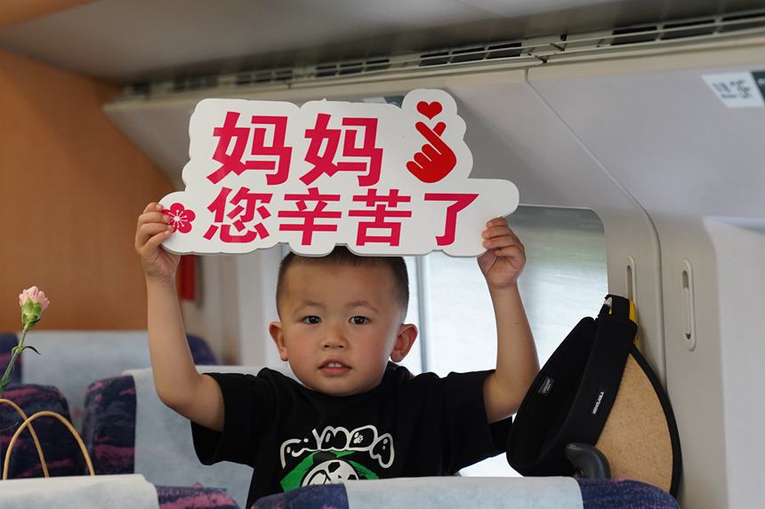 圖16  5月12日，C6409次列車上，小朋友用手持牌向廣大母親送上節(jié)日祝福。李文航攝