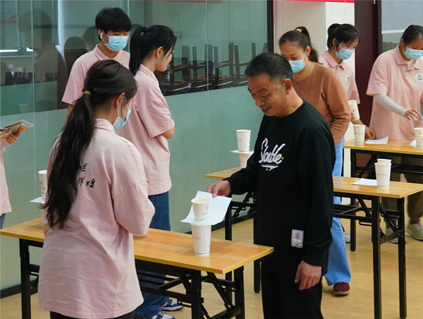 志愿者陪老人玩《看看誰最快》小游戲。重慶城市管理職業(yè)學(xué)院供圖