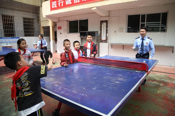 在豐都縣仁沙鎮(zhèn)中心小學(xué)校，該縣稅務(wù)人員與小朋友們利用課間一起打乒乓球。張凌云攝