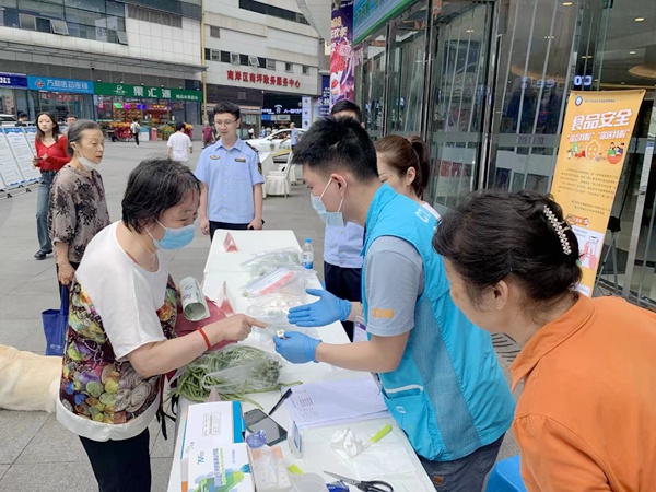 檢驗機構(gòu)人員為市民送檢的蔬菜開展快速檢測。重慶市市場監(jiān)管局供圖