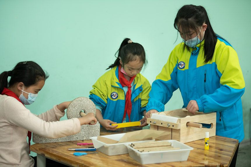 碾艾絨，制艾條?？登f美地小學(xué)供圖