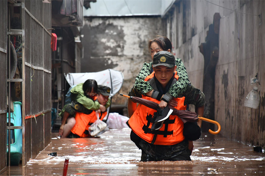 圖為武警官兵轉移受災群眾。徐優(yōu)攝