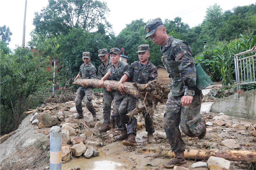 武警官兵清理受災(zāi)現(xiàn)場。李東攝