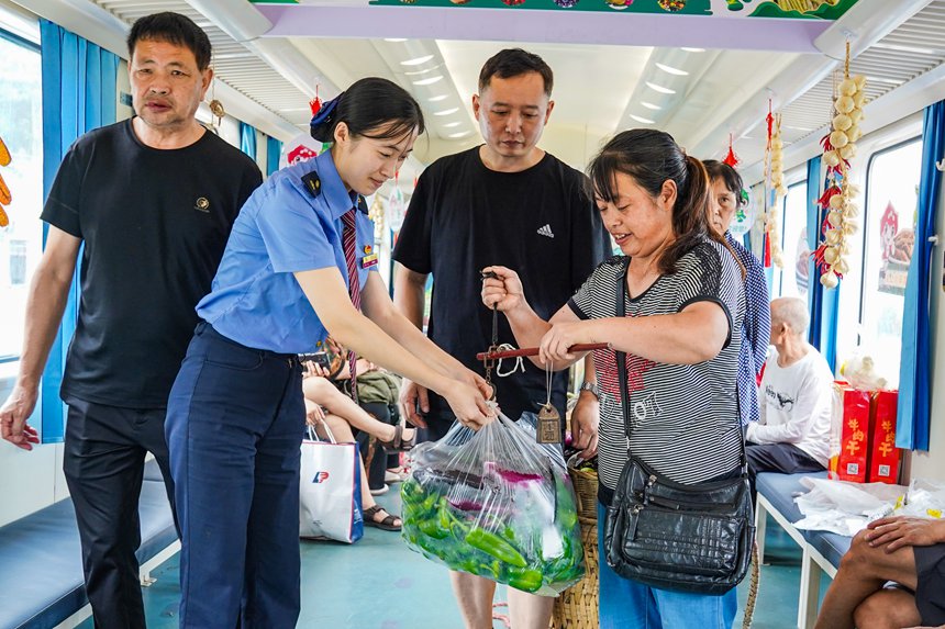 7月11日，5630次列車上，列車志愿者幫助旅客售賣農(nóng)產(chǎn)品。李文航攝