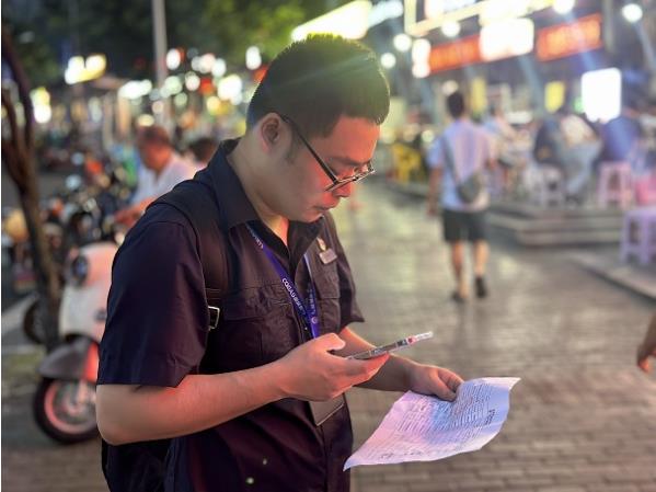 重慶燃?xì)饧瘓F(tuán)沙坪壩分公司工作人員邱韜銘正在路燈下核實(shí)非居民客戶信息。重慶燃?xì)饧瘓F(tuán)供圖