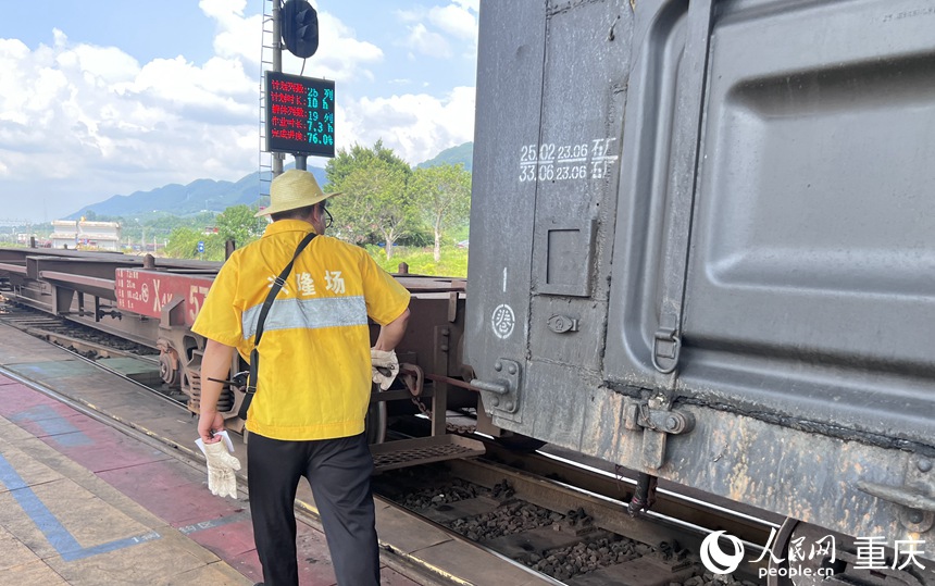 調(diào)車員進(jìn)行駝峰提鉤作業(yè)。 人民網(wǎng)記者 胡虹攝