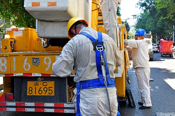 8月15日,在合川區(qū)振興路,帶電作業(yè)人員結(jié)束工作后解下裝備,作業(yè)服已濕透。高愛妮攝