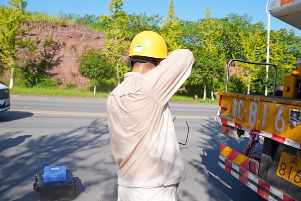 8月15日,在合川區(qū)工業(yè)園區(qū),帶電作業(yè)人員完成作業(yè)后擦拭汗水。高愛妮攝