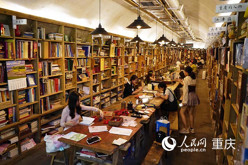 書架沿洞壁擺放，市民游客正在看書學(xué)習(xí)。  人民網(wǎng)記者 劉祎攝
