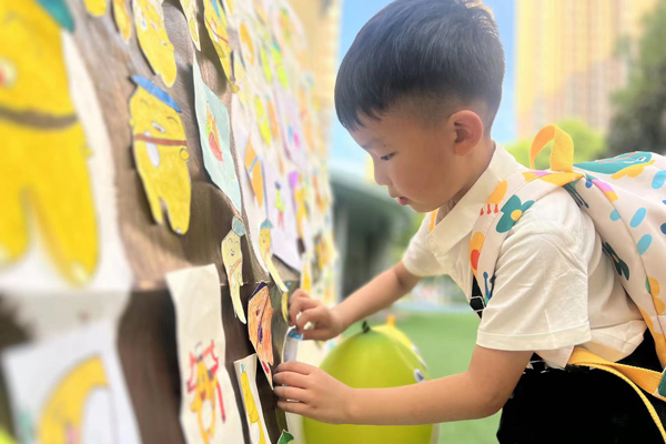 半島逸景園，孩子將“柚寶”貼到柚子樹上。大渡口幼教集團供圖
