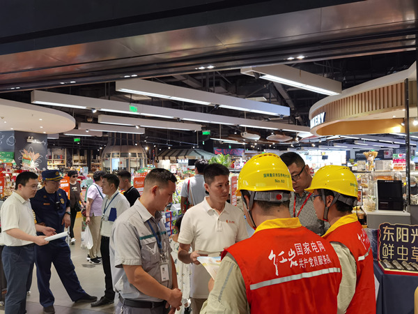 國網(wǎng)重慶市電力公司和重慶市消防救援總隊(duì)工作人員向來福士物業(yè)管理人員及商鋪負(fù)責(zé)人講解安全用電和消防知識。秦雪攝