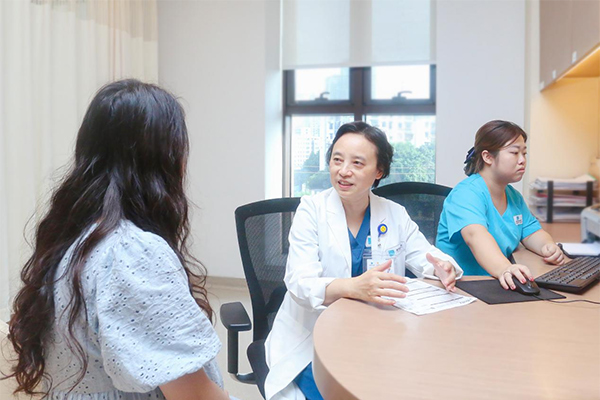 但陽（中）為患者進(jìn)行診療。重慶安琪兒婦產(chǎn)醫(yī)院供圖