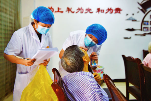 醫(yī)生為老年人進行口腔檢查。陶涵攝