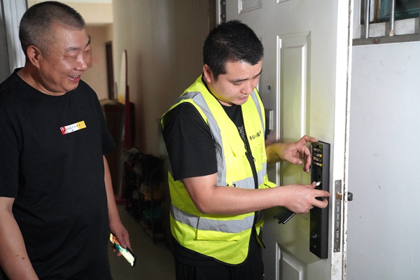 服務(wù)團(tuán)隊為退役老兵何忠明家更換智能鎖。美心集團(tuán)供圖