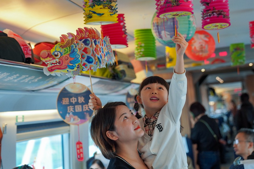 重慶西開(kāi)往貴陽(yáng)北的G4859次列車上，旅客打卡中秋國(guó)慶文化車廂。李文航攝