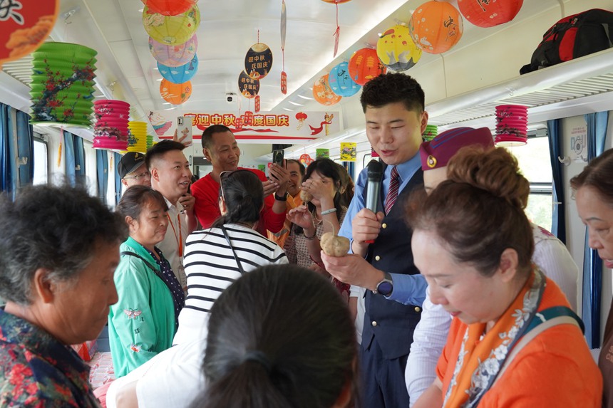 遵義開往重慶西的5630次列車上，旅客在集市車廂購買農(nóng)產(chǎn)品。李文航攝